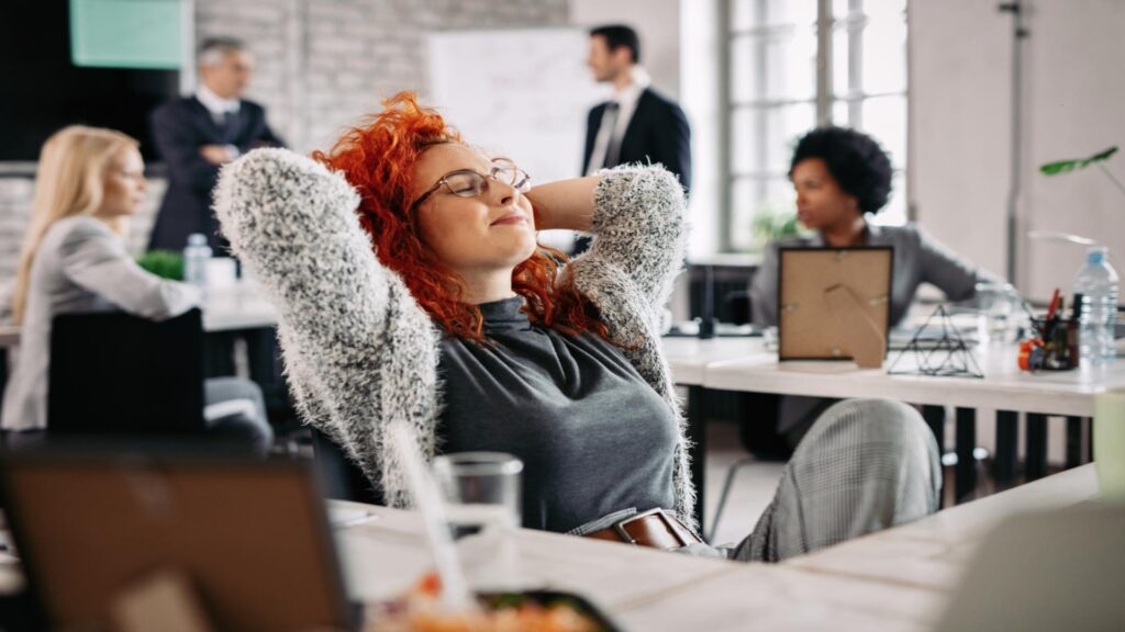 A person relaxing at a desk in a coworking space.